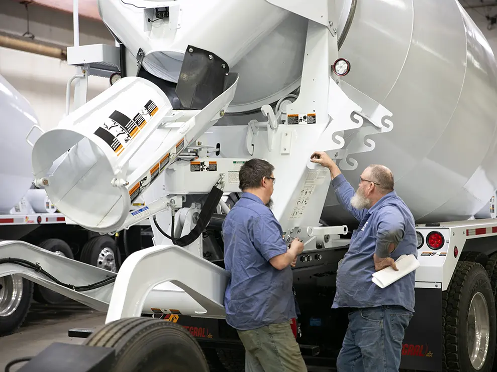 Two SpecSys employees assembling an INTEGRALdx concrete ready-mix truck.