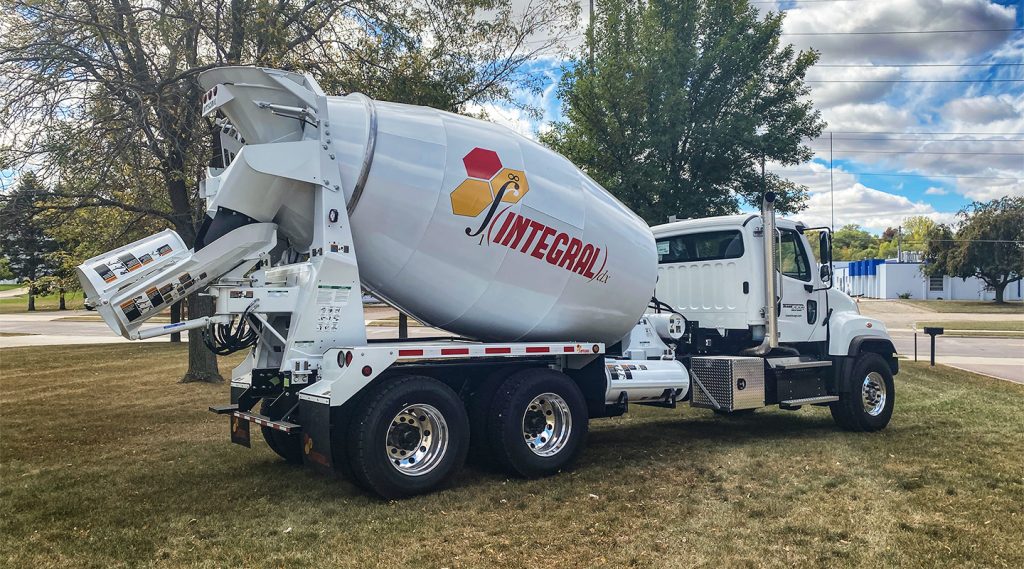 The right rear side of a single white INTEGRALdx concrete redi-mix truck in the conventional style. An INTEGRALdx logo is on the side.