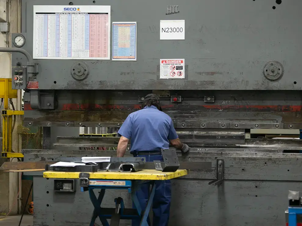 A SpecSys employee pressing metal for an INTEGRALdx concrete ready-mix truck.
