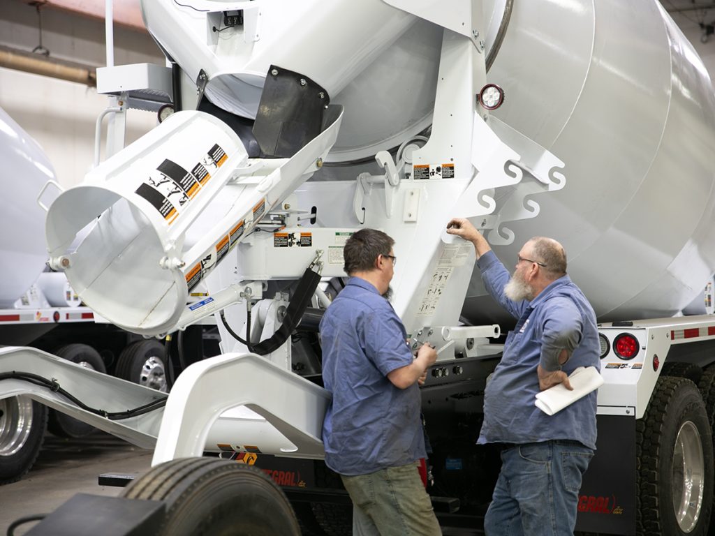Two SpecSys employees looking over an INTEGRALdx concrete ready mix trucks.