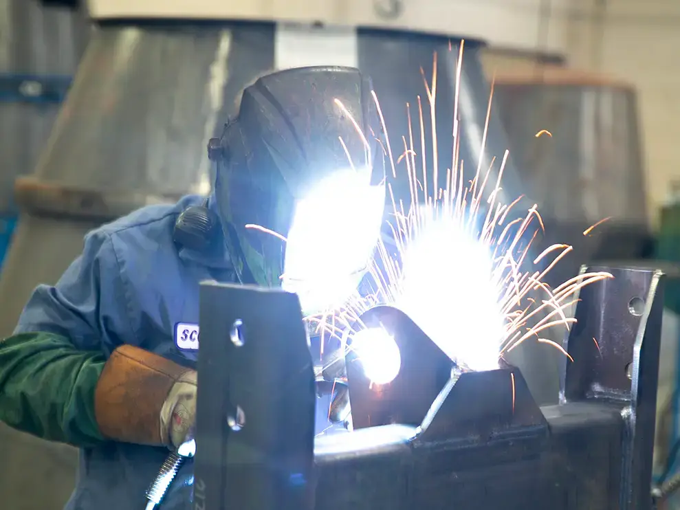 A SpecSys employee welding metal for an INTEGRALdx concrete ready-mix truck.