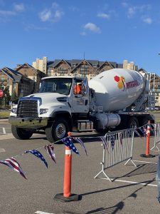 The front left side of a conventional-styled INTEGRALdx concrete redi-mix truck built for TransCHICAGO, who represented us at the National Ready Mixed Concrete Association's annual tournament. An INTEGRALdx logo is visible along the drum. It has a Freightliner chassis.