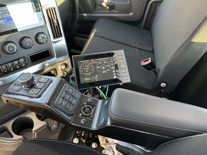 An in-cab shot of INTEGRALdx's RESULTS controls, showing off the 11 button screen and the 12 button arm rest with a joystick